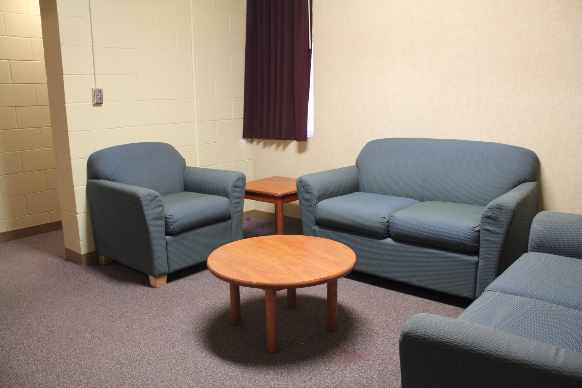 Centennial Complex suite sitting area with 2 loveseats, a chair, coffee table and end table.
