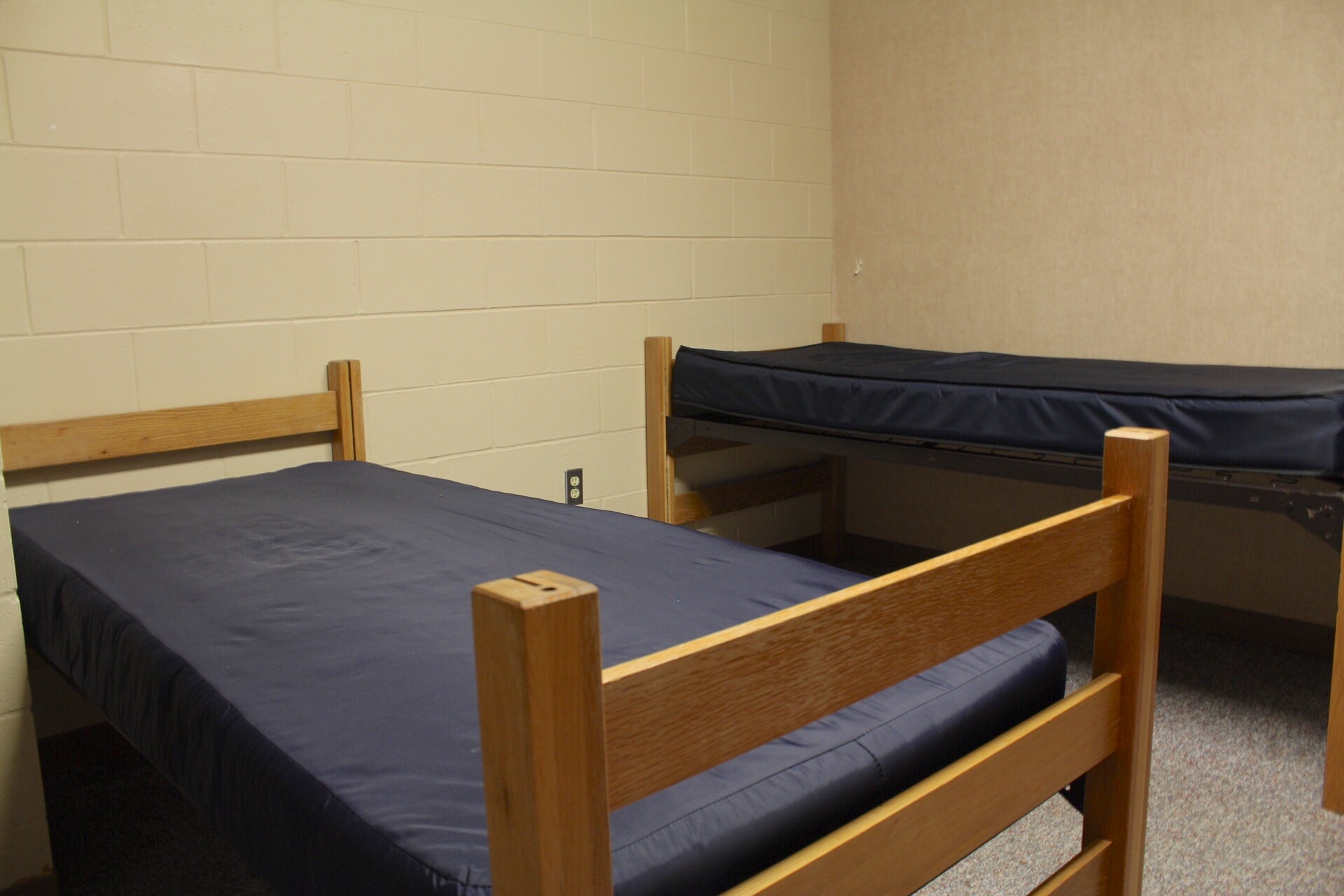 Centennial Complex room with 2 bed frames and mattresses.