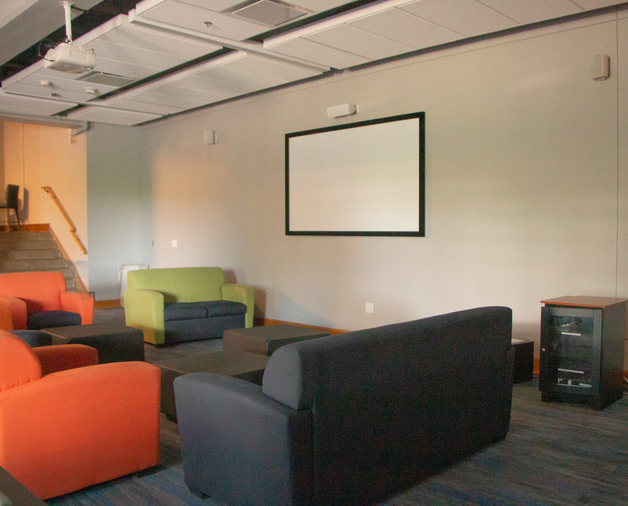 Another view of Delzell Game room seating areas with white wall mounted screen and screen mounted projector.