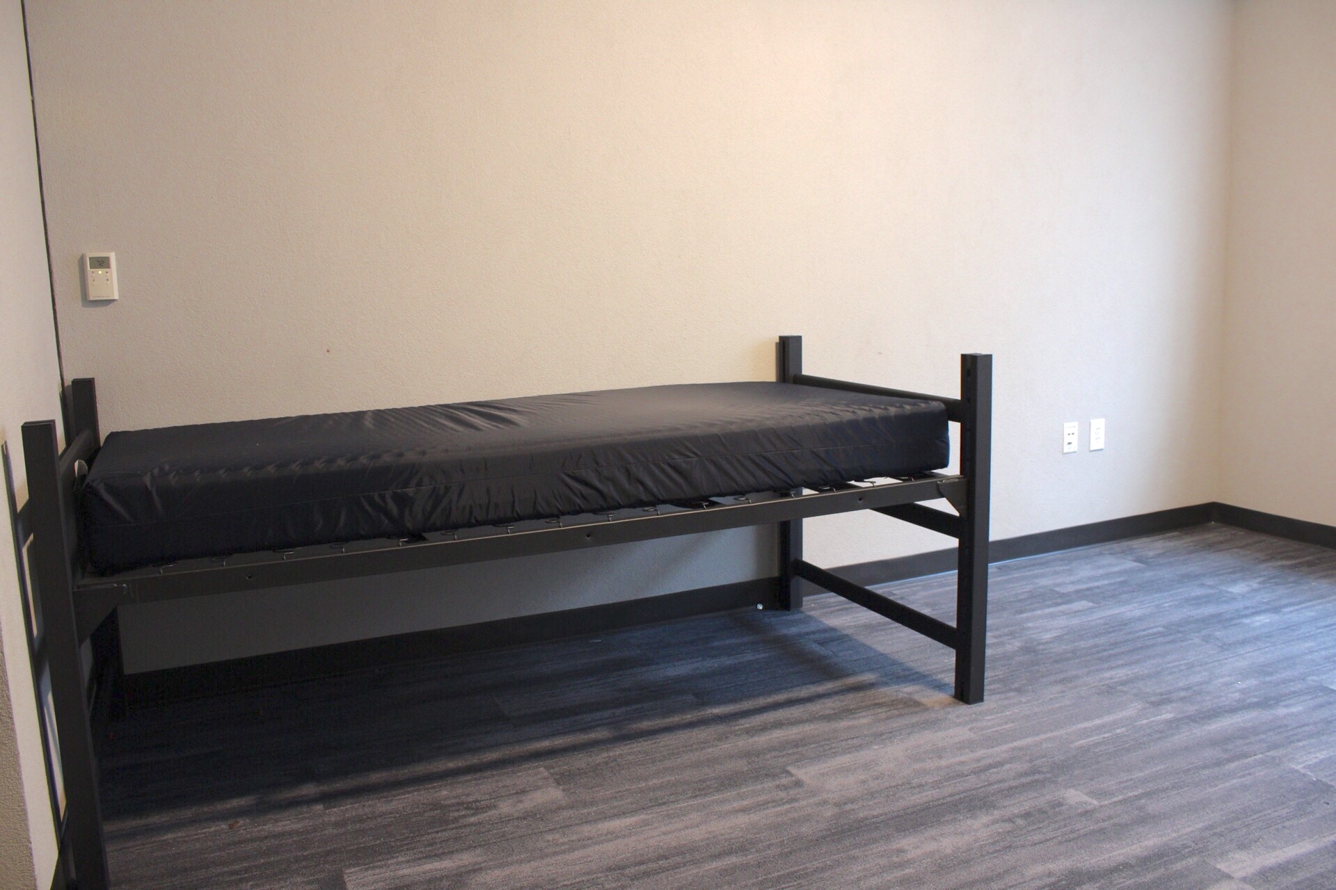 Frame and mattress in a Delzell Hall room.