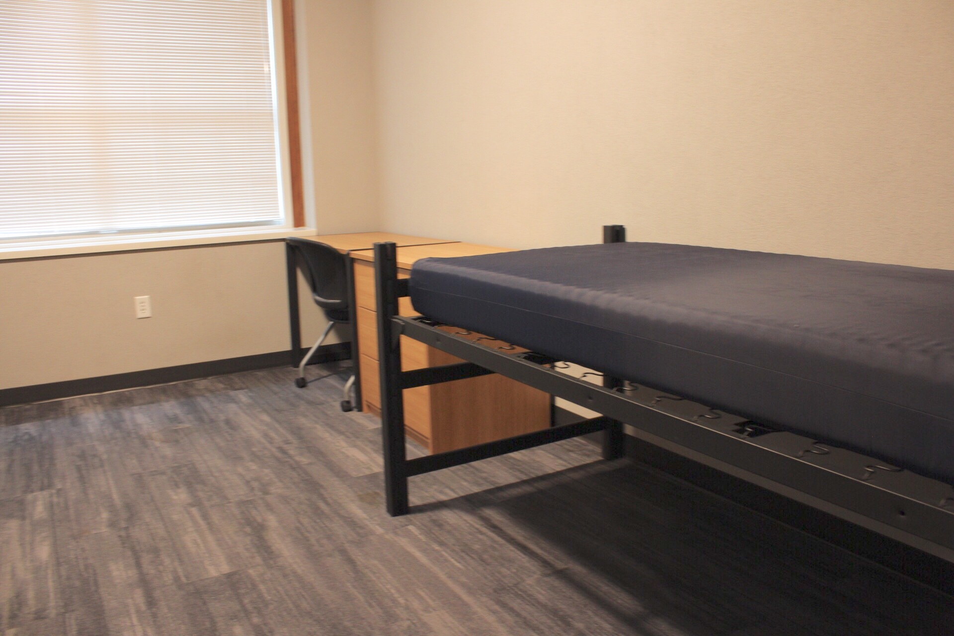 Another view of Delzell hall bed, mattress and desk and chair.