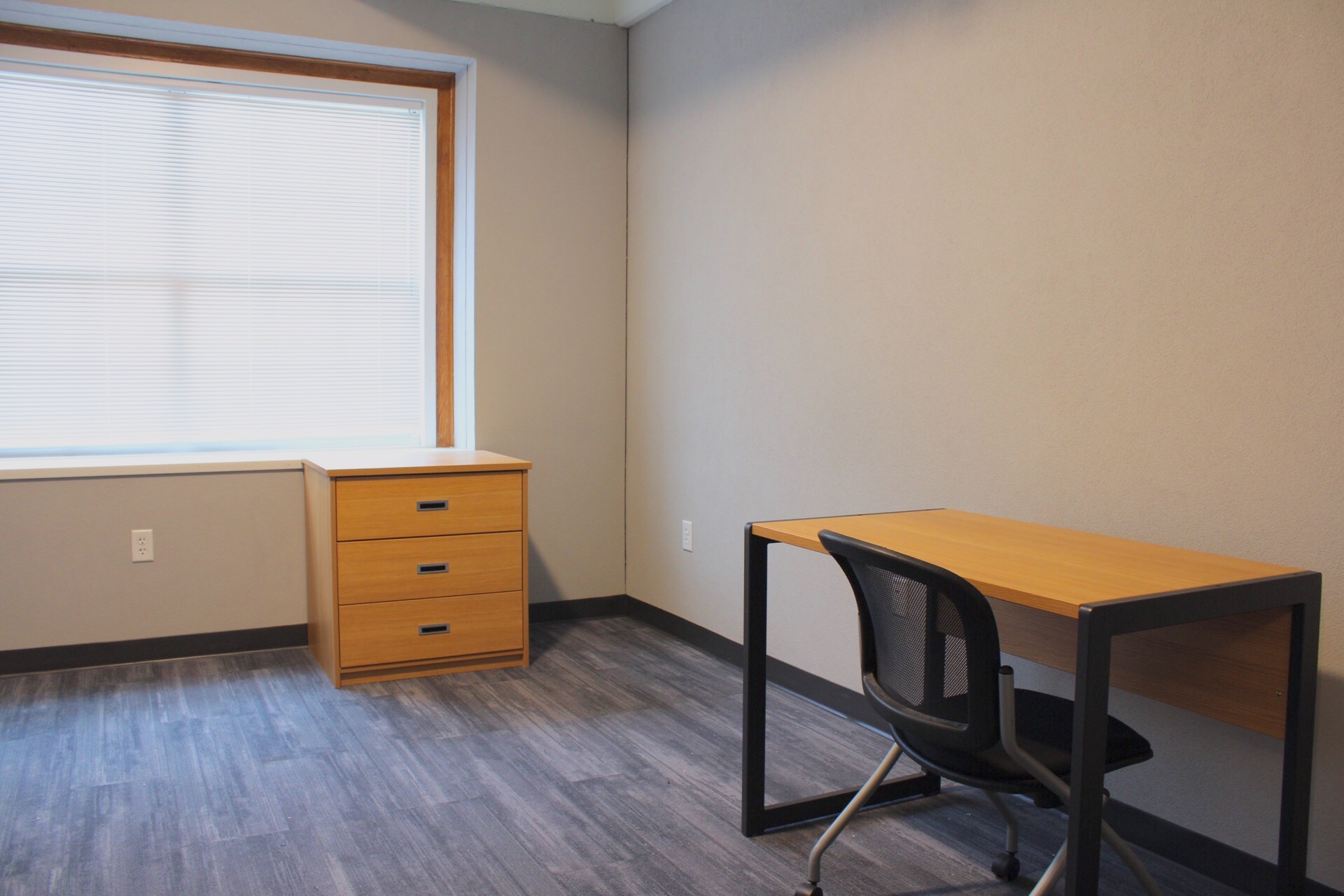 Delzell Hall room with 3-drawer dresser and desk table and chair.