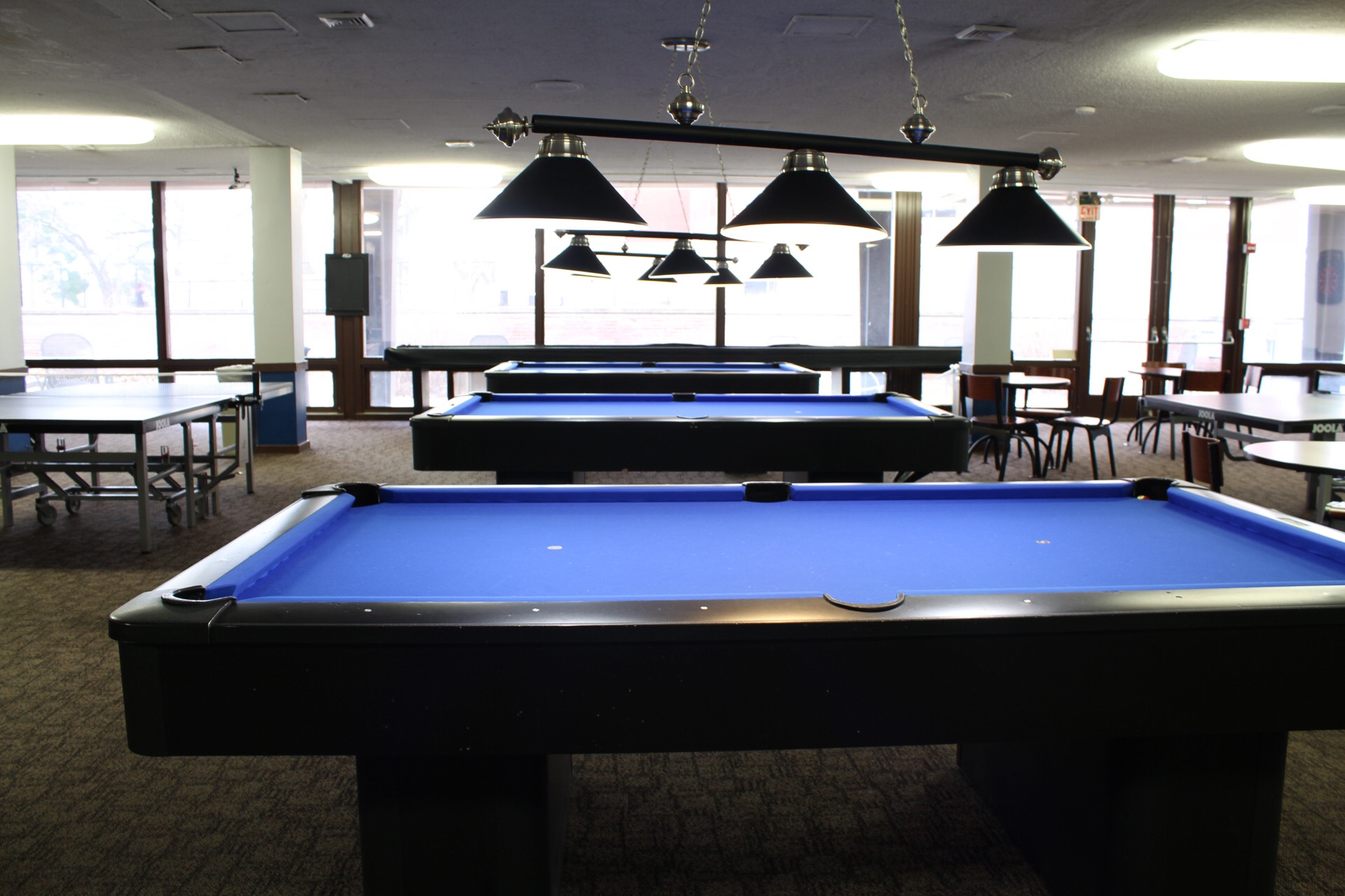Game Room showing 3 pool tables with overhead lighting.
