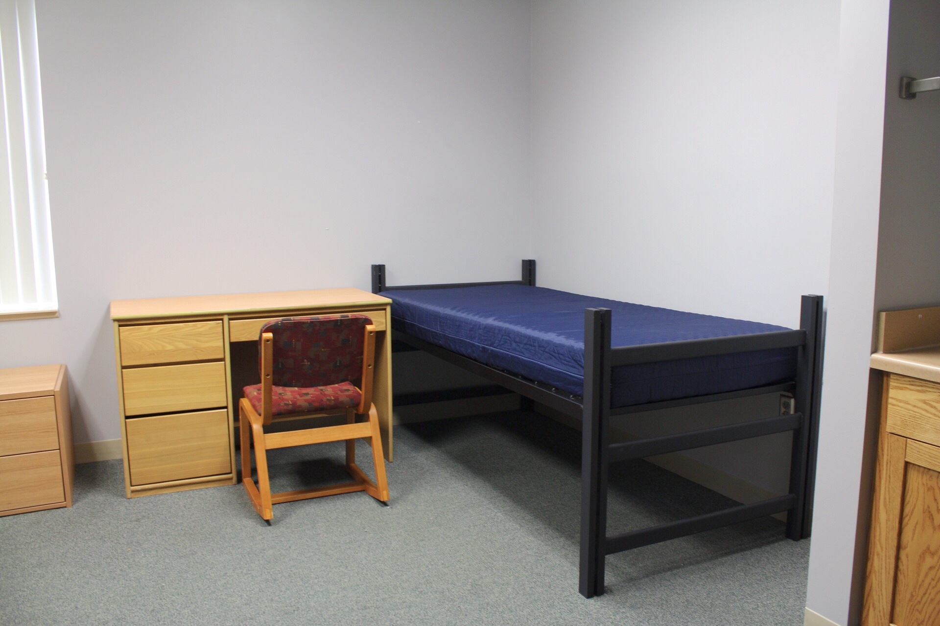 Morgan Hall room showing mattress and frame, desk and chair.
