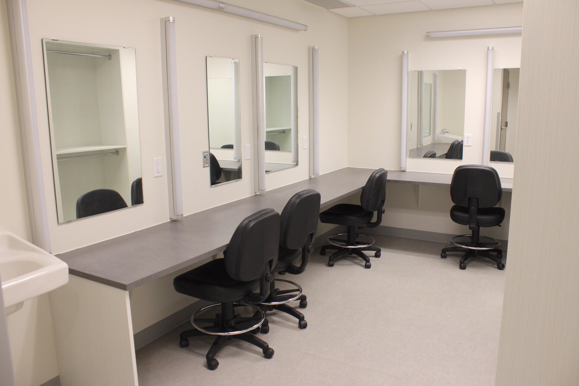 Dressing room with chairs, lights and mirrors.