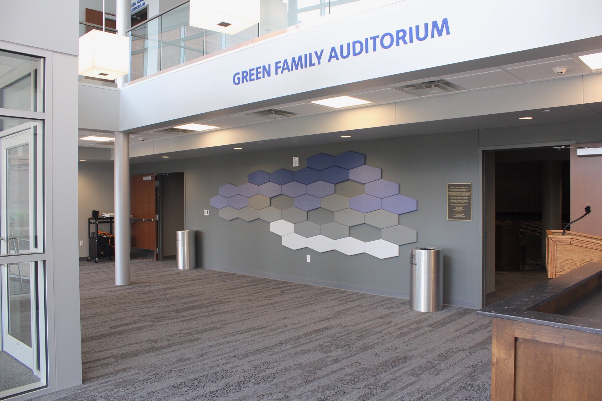 View of the Performing Arts Center lobby with donor plaques on the wall and Green Family Auditorium near the entrance to the auditorium.