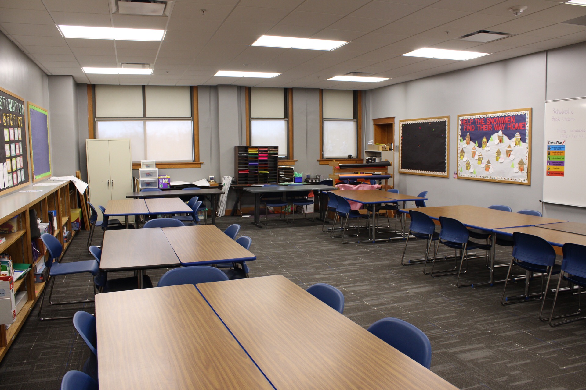 TJ Majors 228 with tables, chairs, whiteboard and decorated bulletin boards.