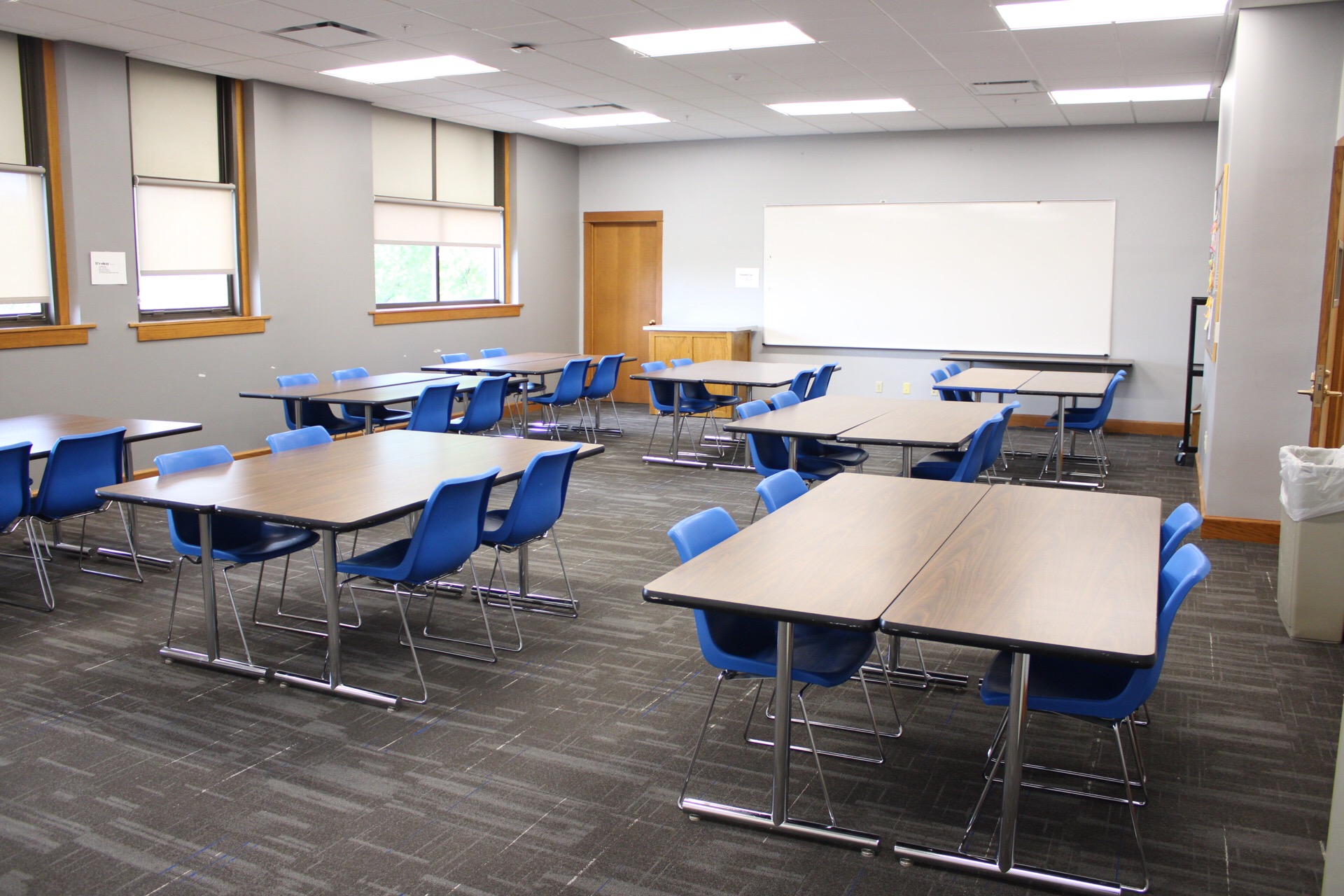 A view of the back of TJ Majors 325 showing tables, chairs and a large whiteboard.