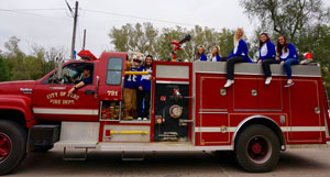 Peru State's cheerleaders rode the fire trucks during Peru State's Homecoming Parade. 