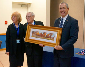 Dr. Dan Hanson presents a print of the Peru State College Sesquicentennial Painting by Todd Williams to Grand Marshal Jackson Howard and his guest, 