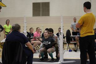 Bailey Kuhlman under the bar at a competition in March.