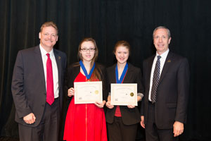 Erica McMullen and Emma Porter receive First Place for Senior Group Interpretive Website with Todd Simpson, Executiv e Director of the Peru State College Foundation (left) and President of Peru State College, Dr. Dan Hanson (right)