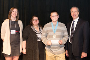 Phi Alpha Theta Secretary/Treasurer Samantha Jackson and PAT President Michelle Kaiser present the Michelle A Broady Award for Extraordinary Determination to •Brennan Gress with President of Peru State College, Dr. Dan Hanson