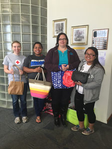 Students holding donations they prepared for Project Response: Left to Right: Chelsea Turek, President, Peru State College Red Cross Club Janessa Davis, President, Peru State College Black Student Union Shari Berglund, Project Response Marissa Gomez, Vice President, Black Student Union