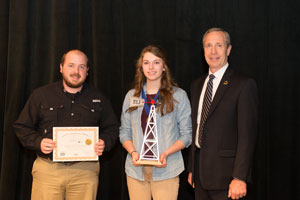 Dean Shissler (left), director of the Kregel Windmill Factory Museum, presents a special award to Kacie Hahn with Dr. Dan Hanson, President of Peru State College (right).
