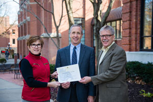 Dr. Dan Hanson accepts a certificate declaring the Gran Fondo a signature event from members of the Nebraska State Sesquicentennial Commission, Dr. Sara Crook and Dr. Dan Holtz.