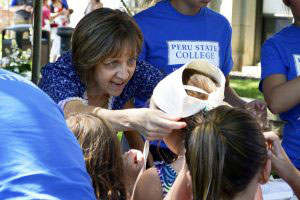 Lori Broady places a bonnet on the head of a visiting child.