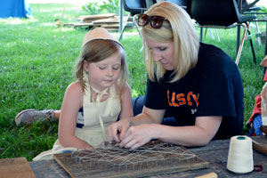 Quinlee Sayer working on Nebraska-themed string art with 4-H Extension Office volunteer, Alison Mullins.