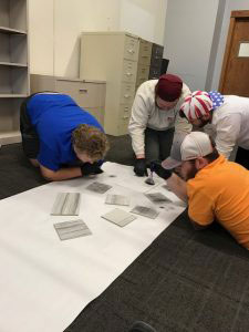 A group of 4 students working on the floor.