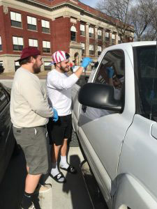 2 students dusting a white truck for finger prints.