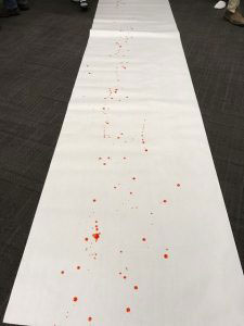Close up of blood spatter on white flooring.