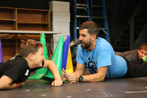 Dillion Leffler, a HTRS sixth grader, knocks over a cone in a competition with Peru State teacher candidate, 