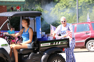 During the parade, Britnee Hart (Peru) drives while Professional Staff Senate Member Ted Harshbarger refills his candy supplies.