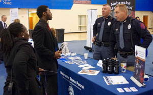 Representatives of the Nebraska State Patrol speaking to a potential recruit on the Peru State College campus. Photo courtesy of Dr. Bill Clemente.