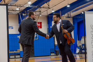 Vijay Gupta shaking the hand of the introductory speaker, Peru State student Gunnar Orcutt.