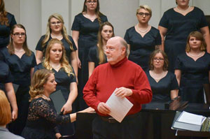 Jackson Berkey of Manheim Steamroller was the guest composer at the Peru State Choir concert, Heritage held Thursday. The Women's Choir stand behind him with staff accompanist, Liz Stinman, at the piano. 