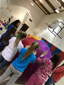 Students rolling a large inflated ball.