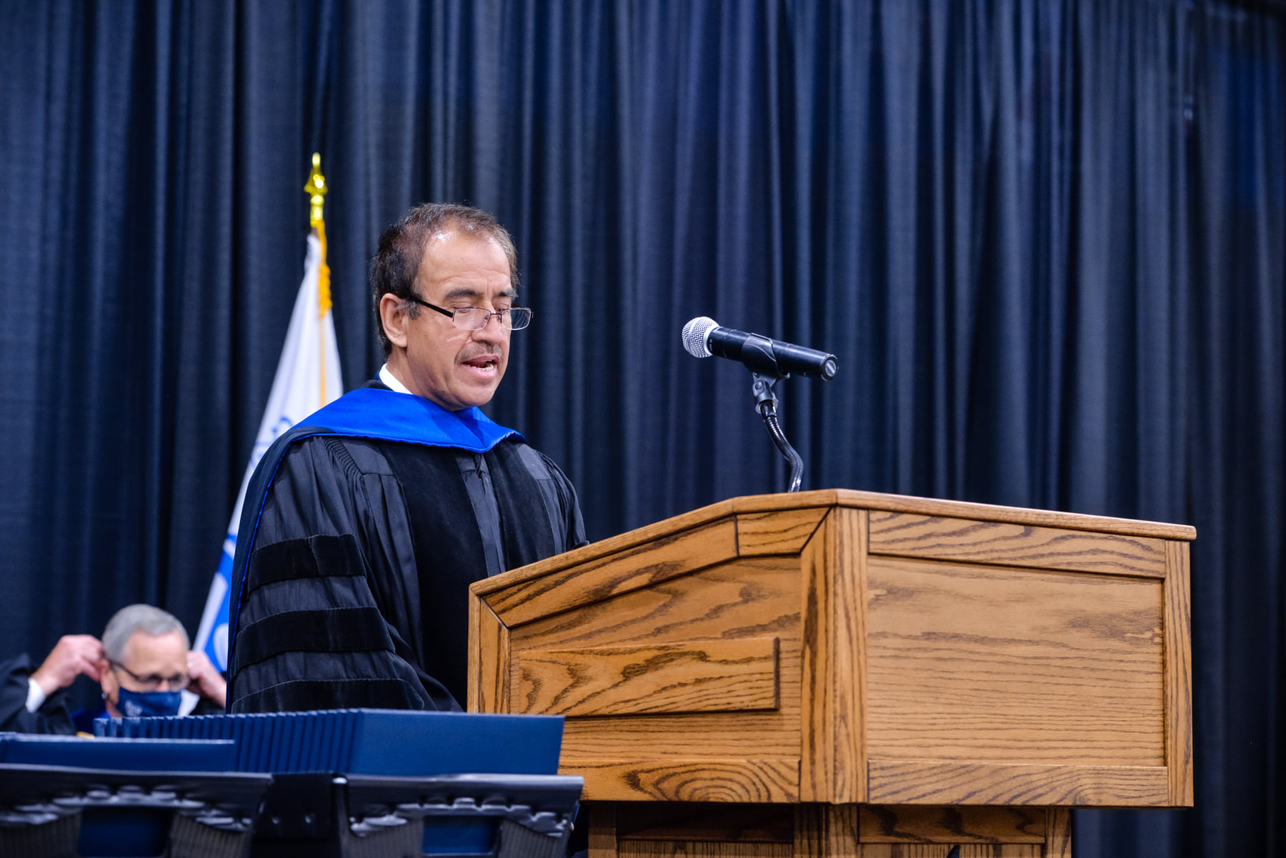 Dr. Gul Ahmad speaks at the podium during commencement.