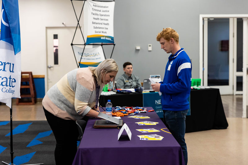 Student meeting with a potential employer at a career fair booth.