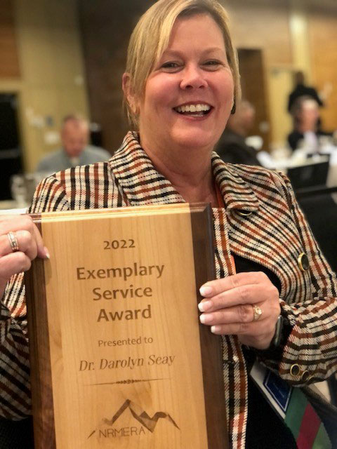 Dr. Darolyn Seay holding her NRMERA Exemplary Service Award