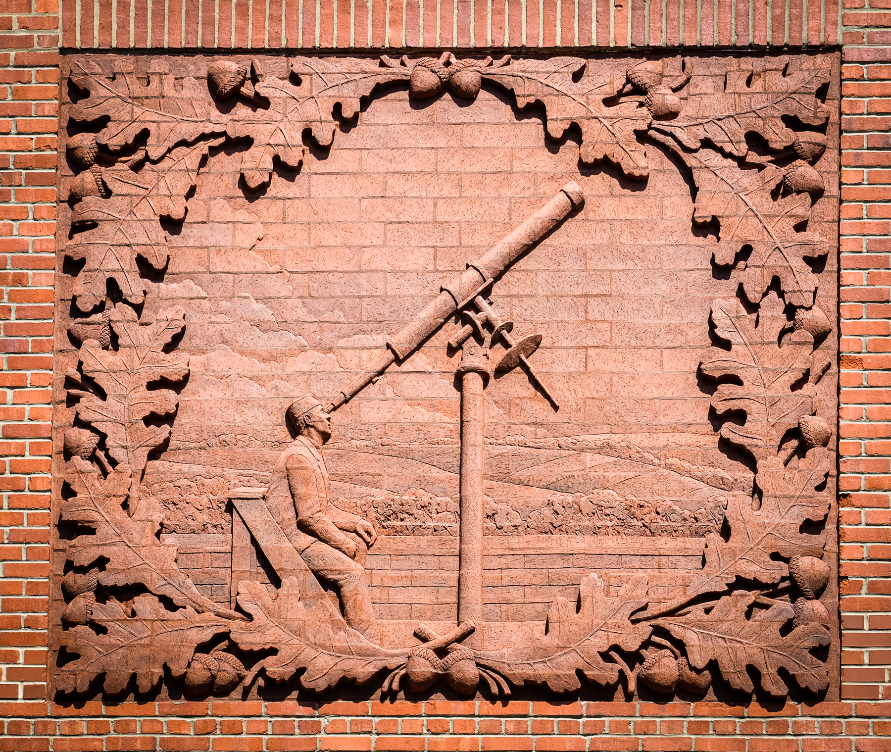 Close up view of the brick relief on the theatre showing W.H. Hoyt, long time faculty member and namesake of Hoyt Science Hall searching the skies with a telescope.