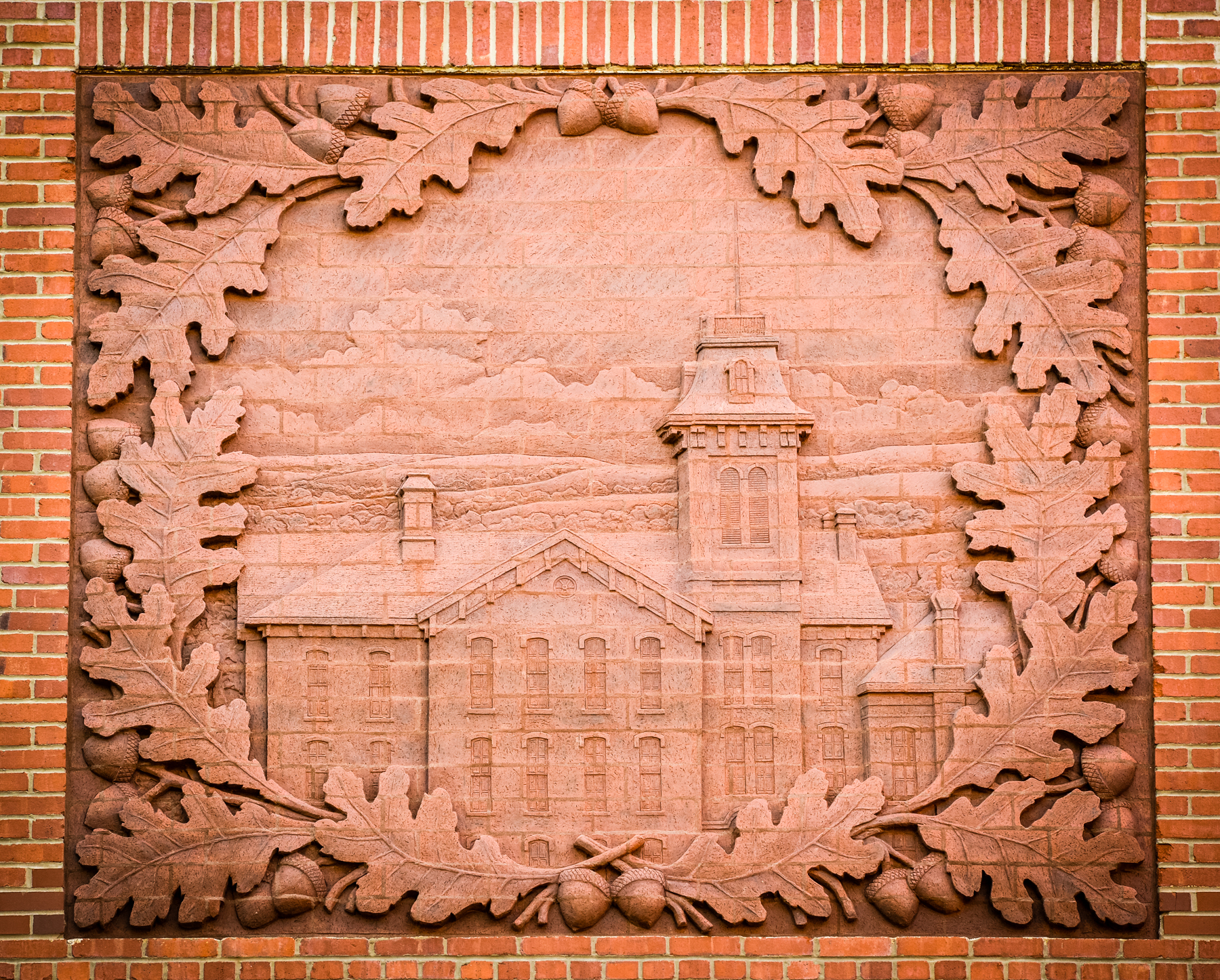 Close up view of the brick relief on the theatre wall showing Normal Hall, most often referred to as Old Main, the original building in the space occupied by Hoyt Hall and the College Theatre.